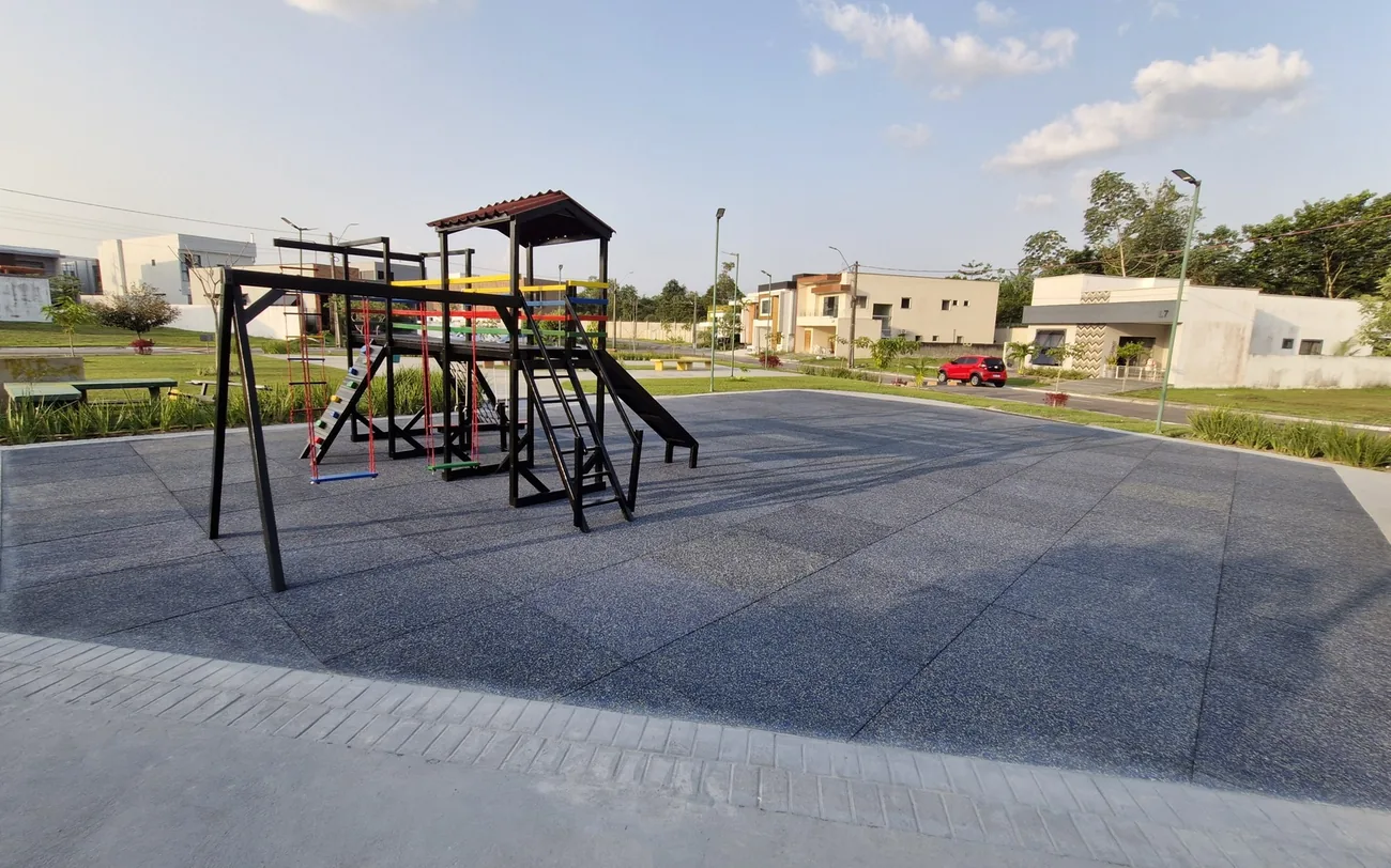 A mesma área de lazer depois da reforma, com piso emborrachado novo e playground recuperado e pintado