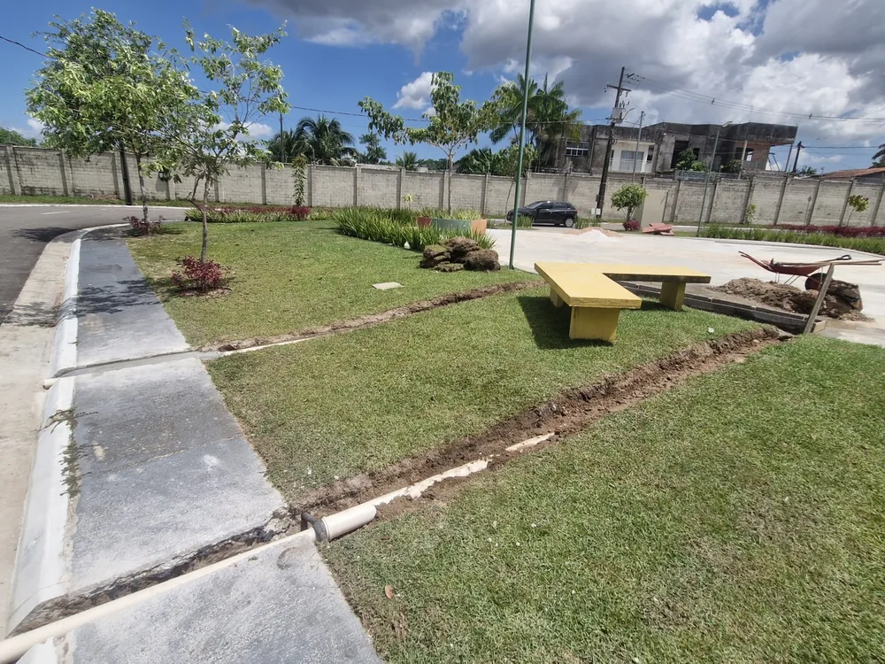 Vala de drenagem aberta ao longo do canteiro da praça