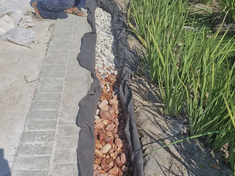 Assentamento de pedra na canaleta de drenagem